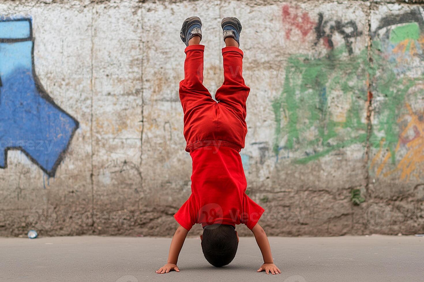 A young boy doing a handstand on a skateboard photo
