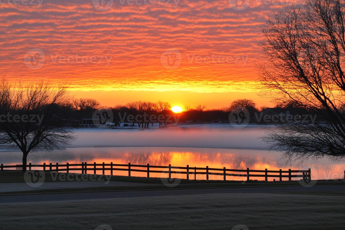 A beautiful sunset over a lake with a fence photo