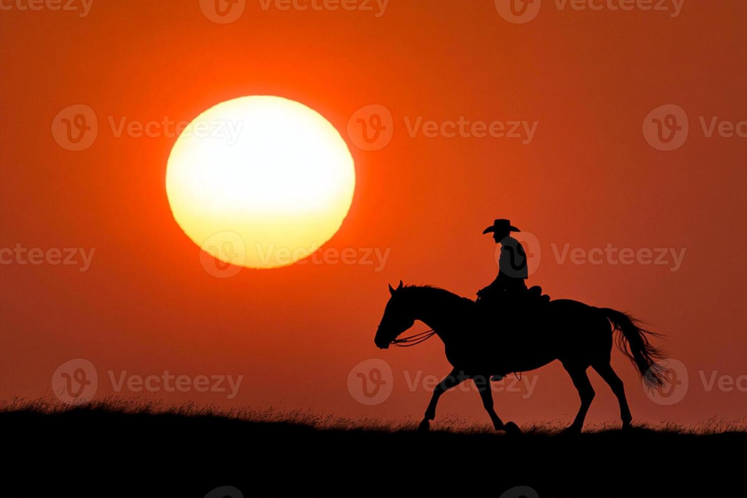 A cowboy riding a horse in the sunset photo