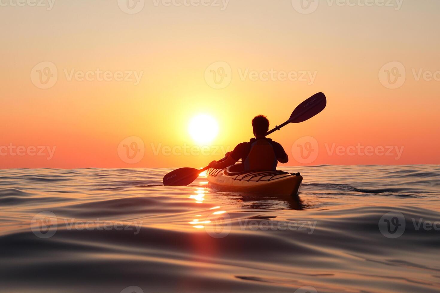A person in a kayak paddling at sunset photo