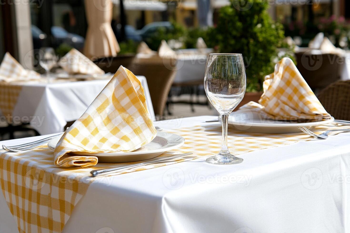 A table with a white tablecloth and yellow checkered napkins photo