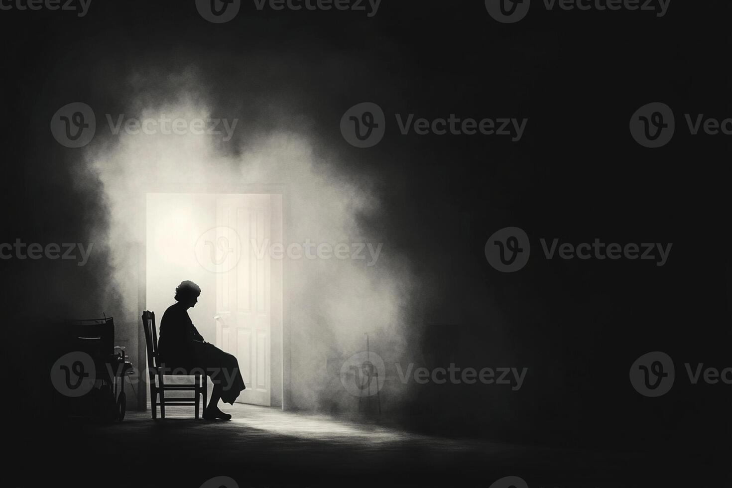 A man sitting in a chair in a dark room photo