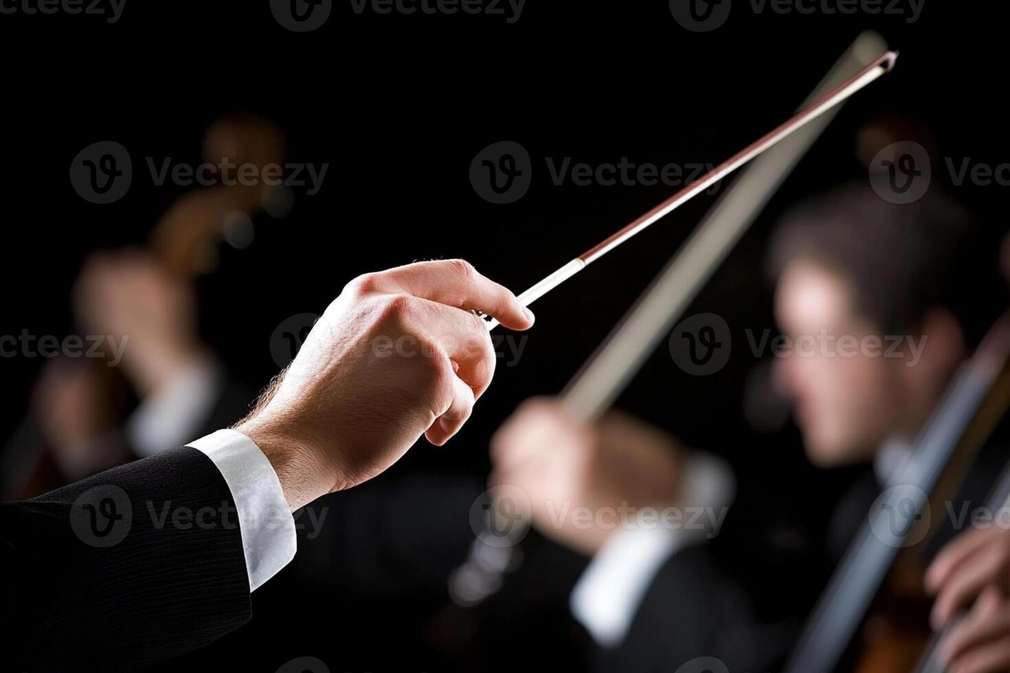 A conductor holding a baton in front of a group of musicians photo