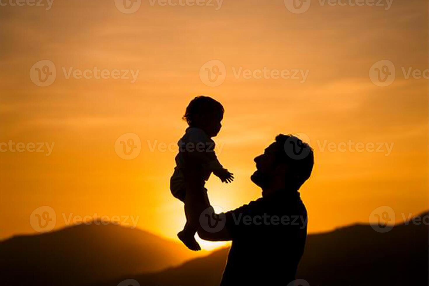 Silhouette of a father holding his child at sunset photo