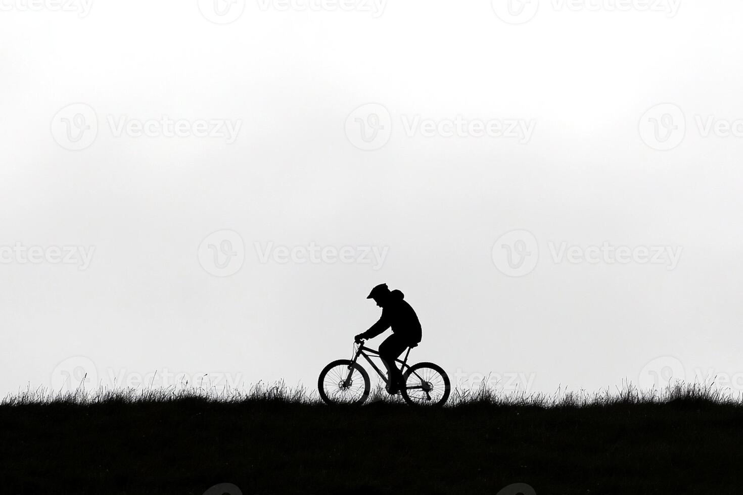 A person riding a bike on a hill photo