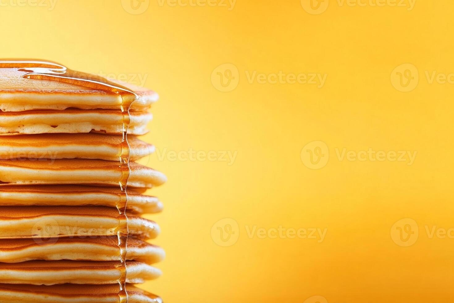 Stack of pancakes with syrup on yellow background photo