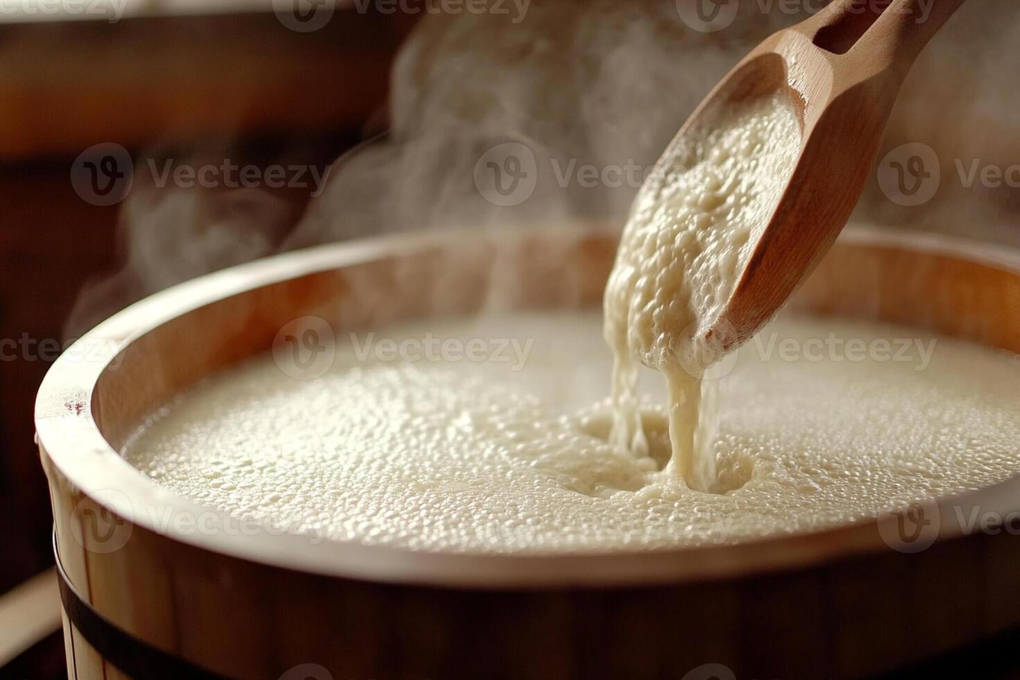 A wooden spoon is being poured into a wooden bowl photo