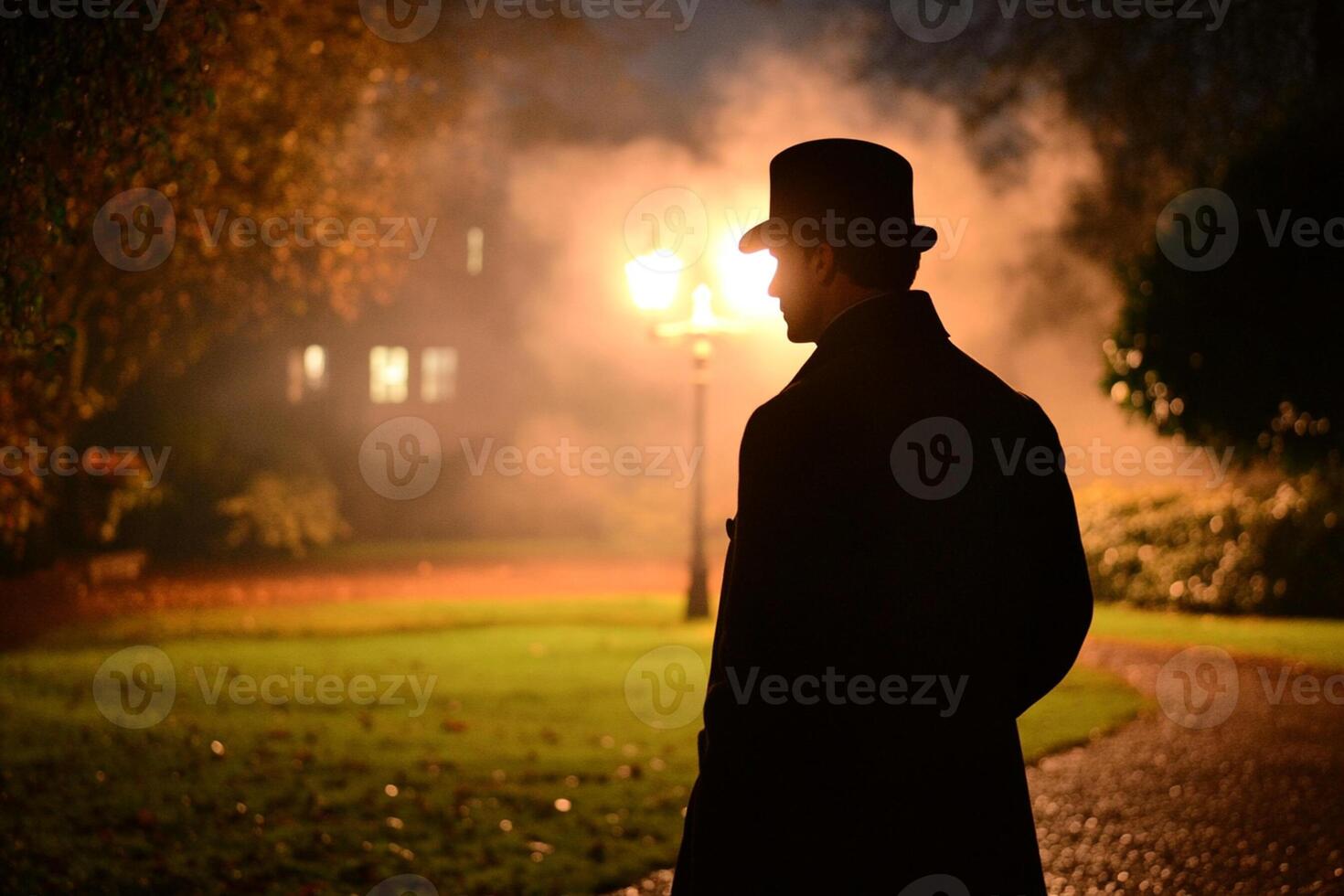 A man in a top hat and coat standing in the dark photo