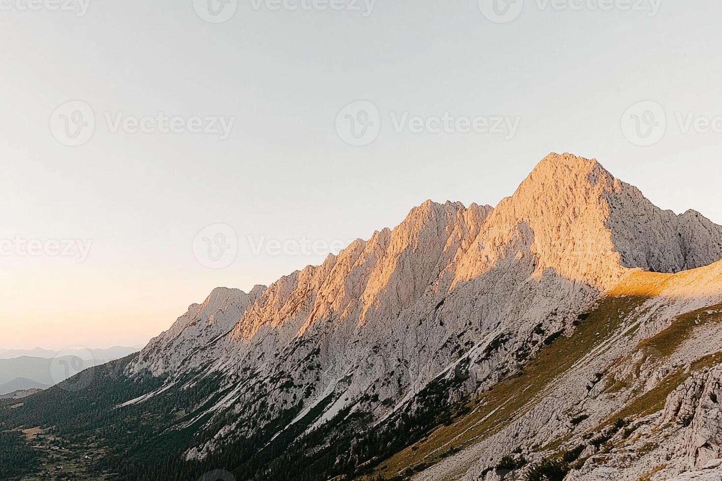 A mountain range in the sun with a person standing on top photo