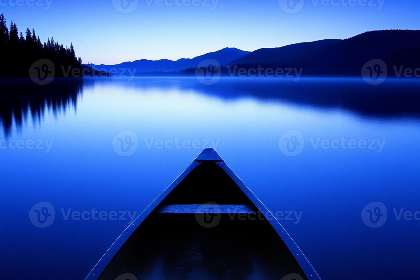 A canoe is sitting on the water at dusk photo