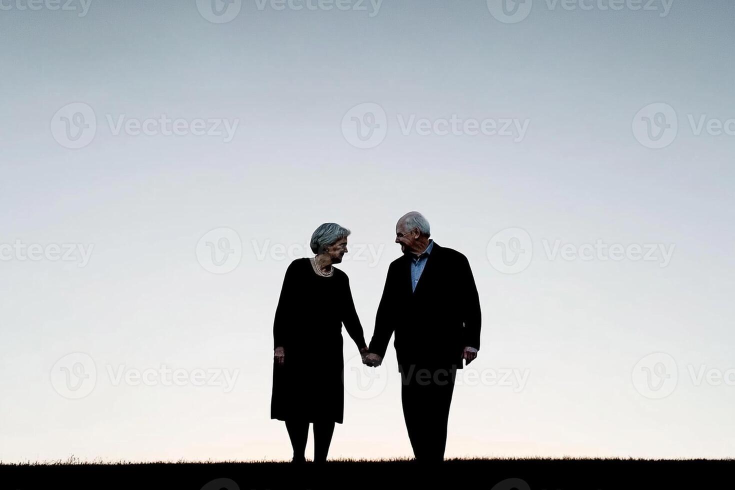 A couple holding hands in silhouette on a hill photo