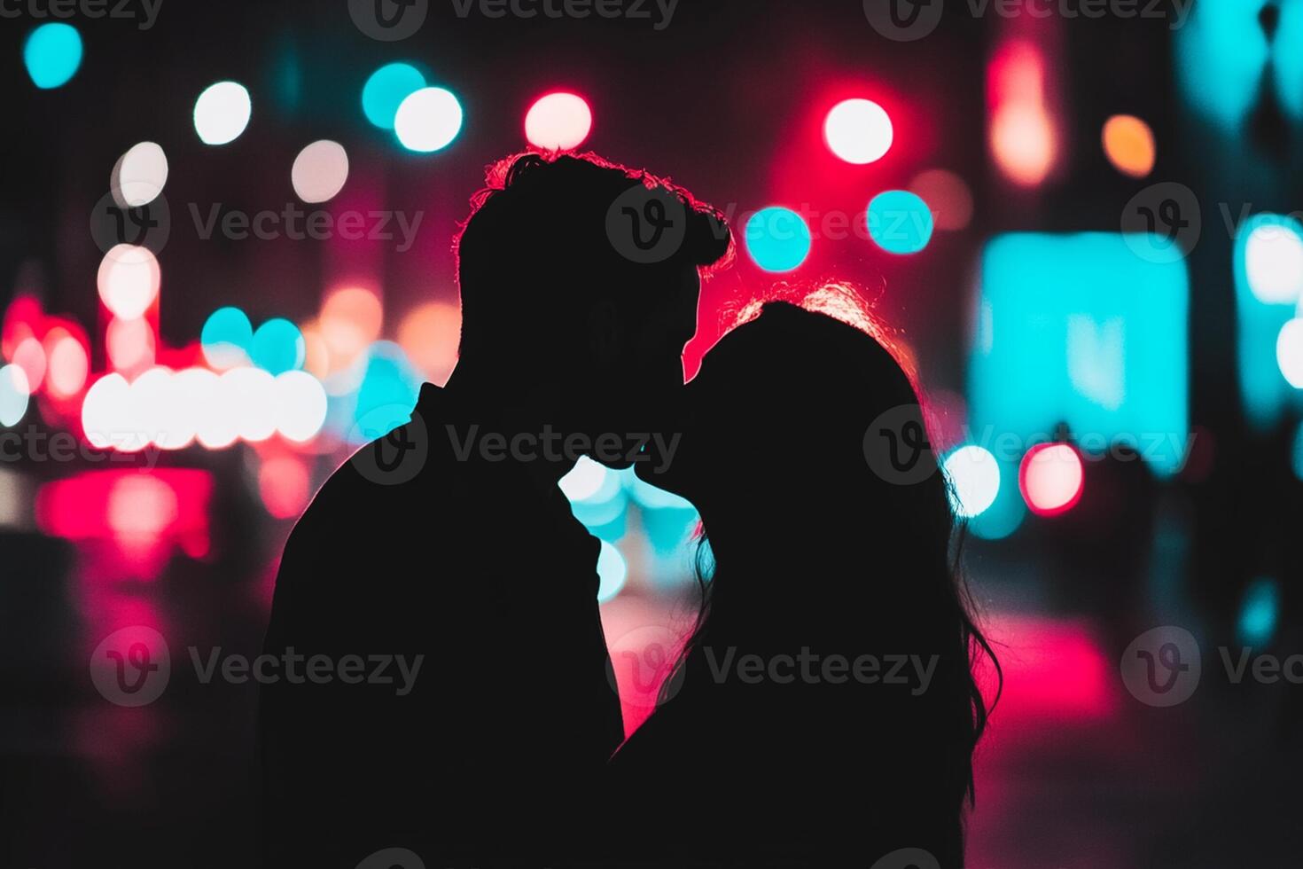 Couple kissing in the city at night photo