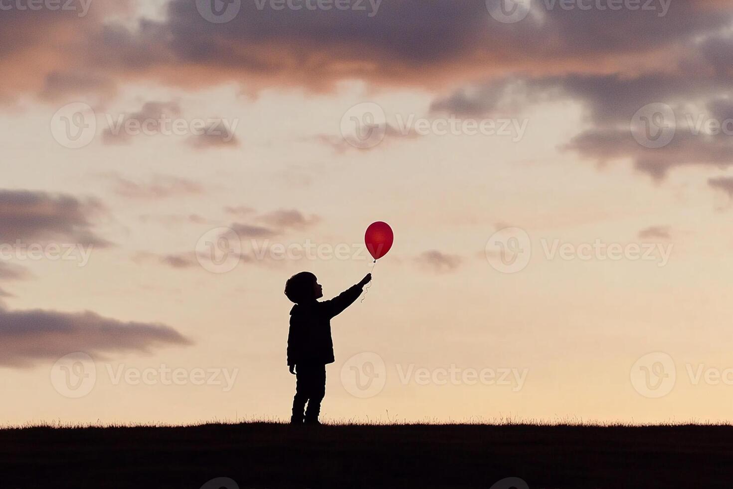 A child holding a red balloon in the air photo