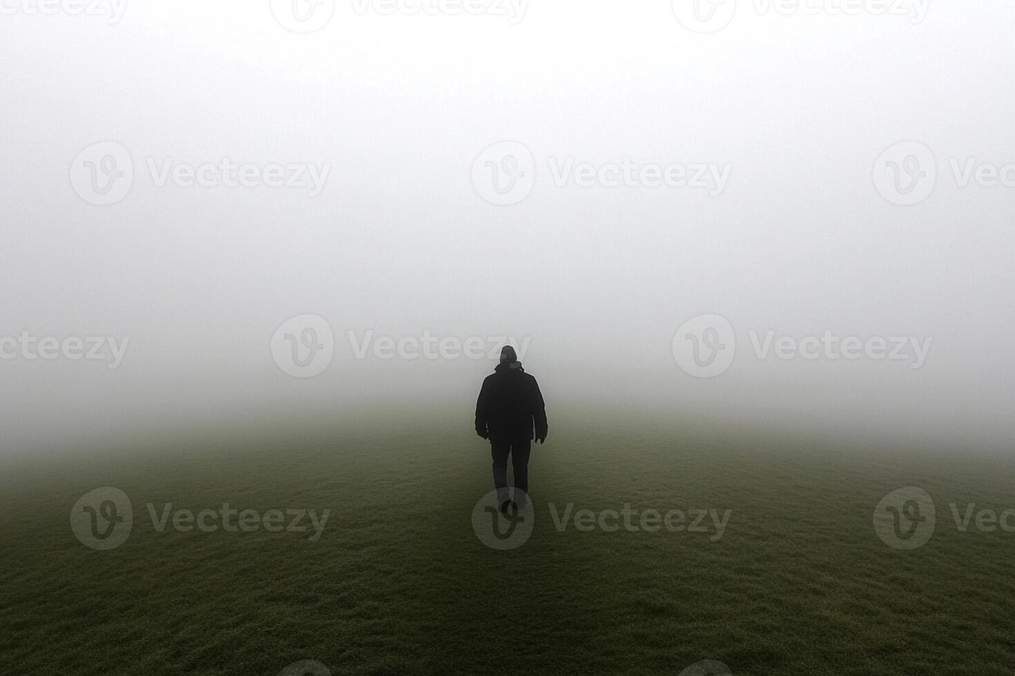 A man standing alone in a foggy field photo