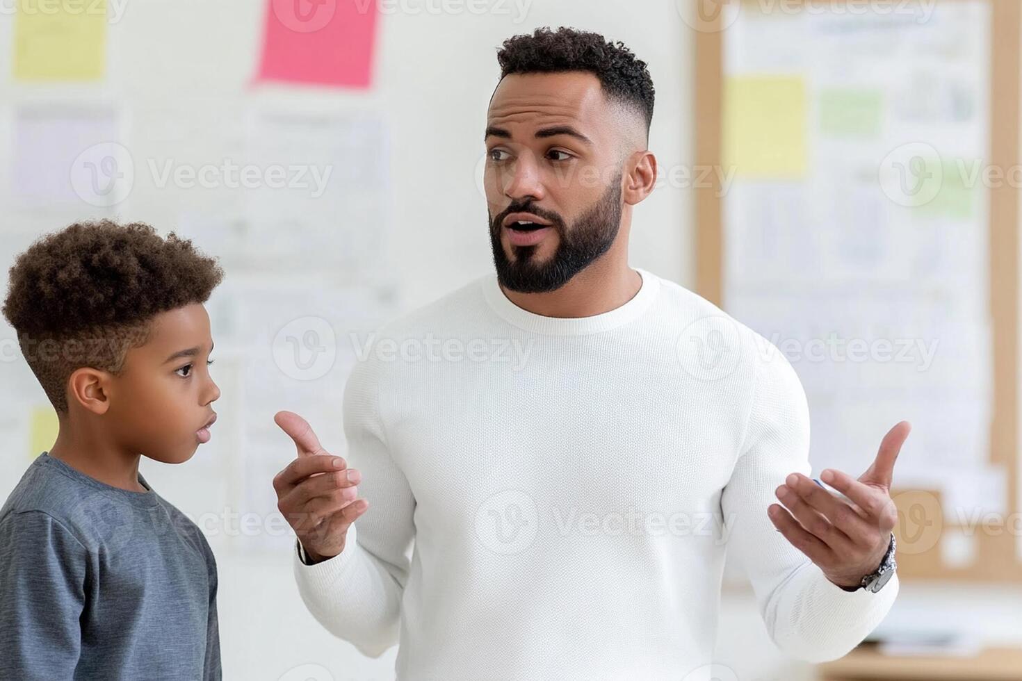 A man and a boy are talking in a classroom photo