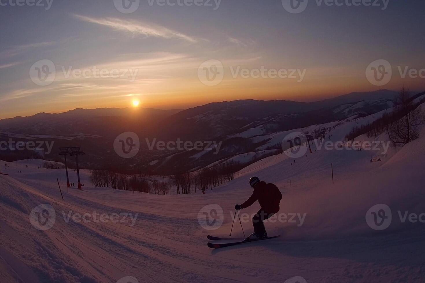 A person skiing down a slope at sunset photo