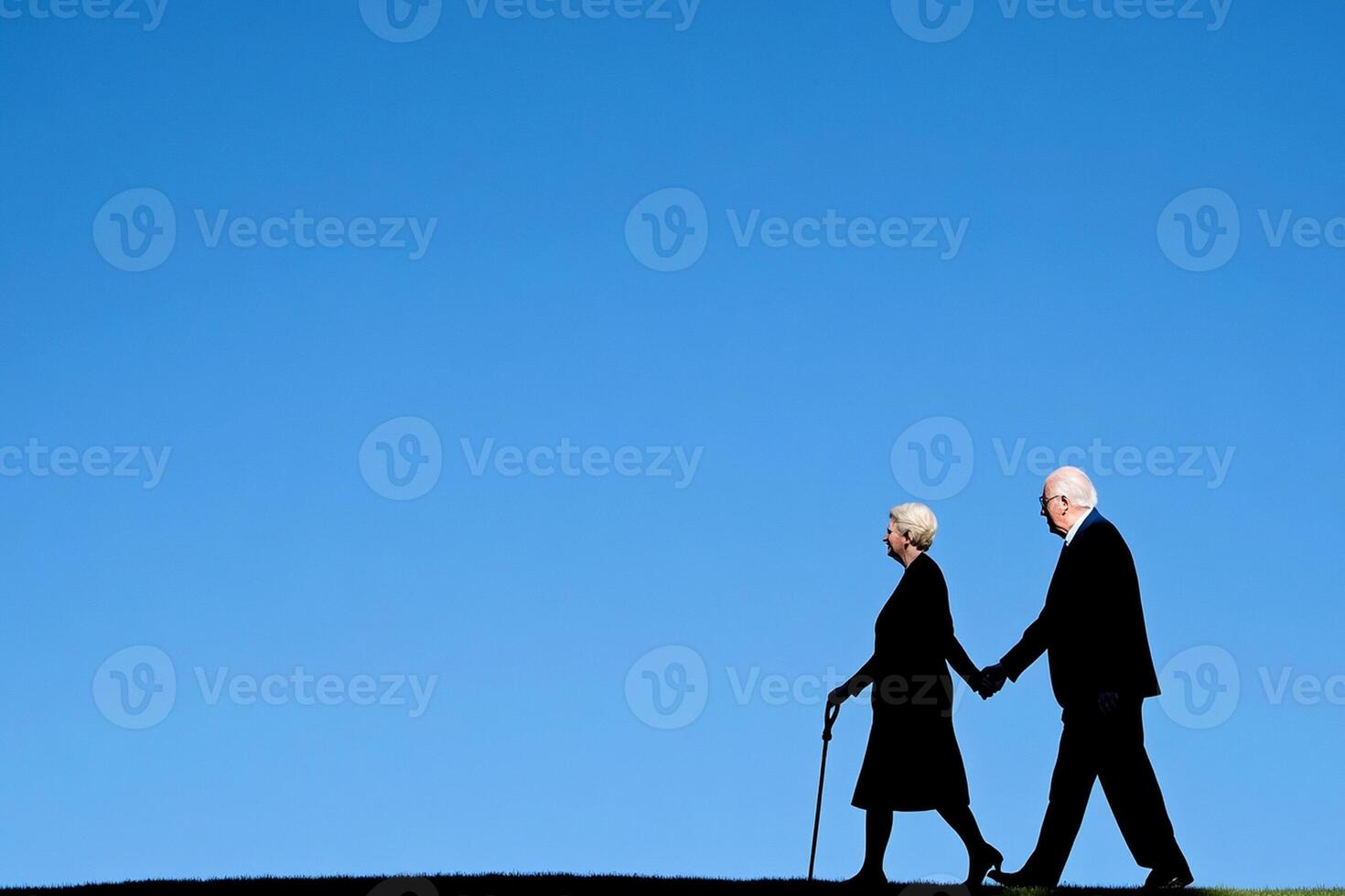 An older couple walking on a hill photo