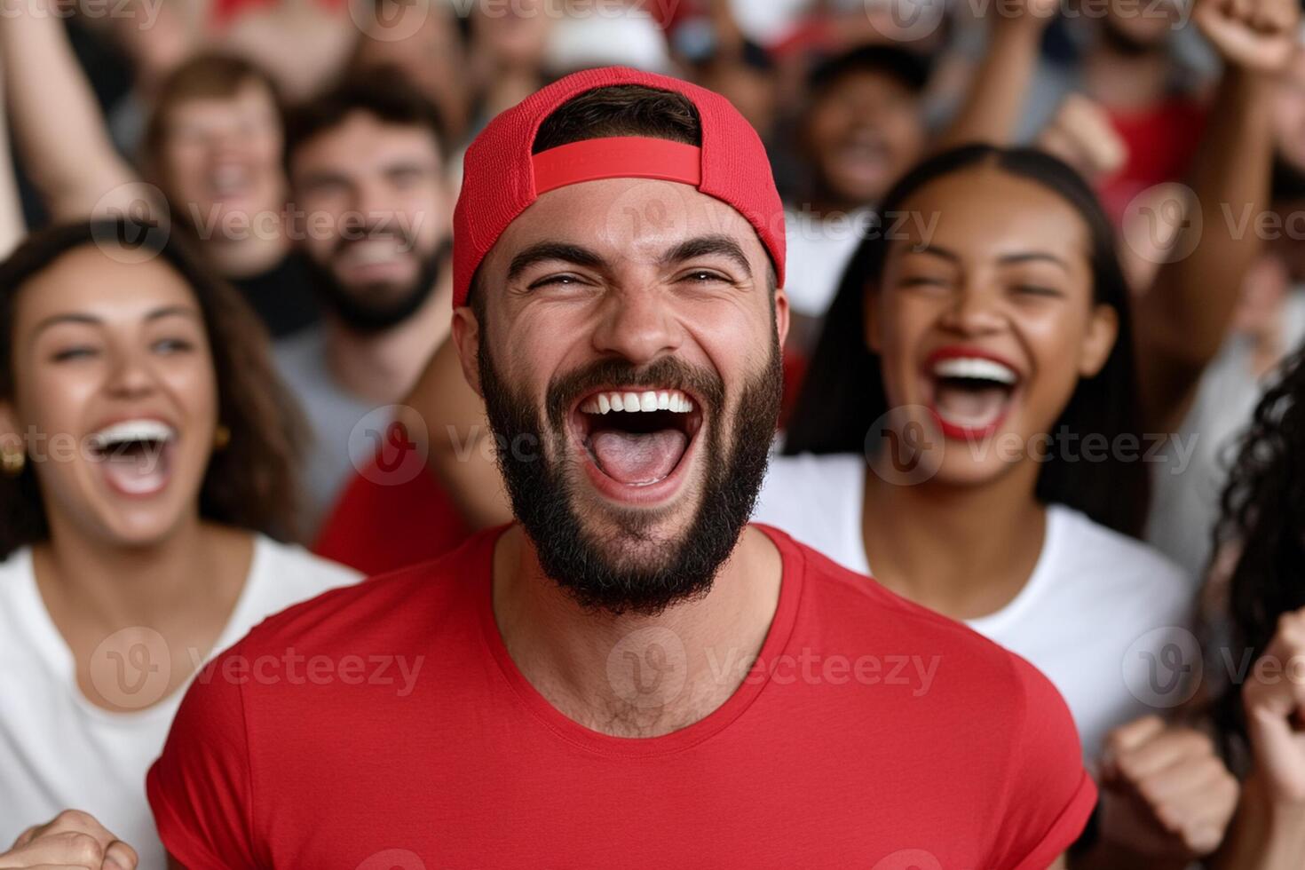 A man with a beard and red shirt is cheering with his mouth open photo