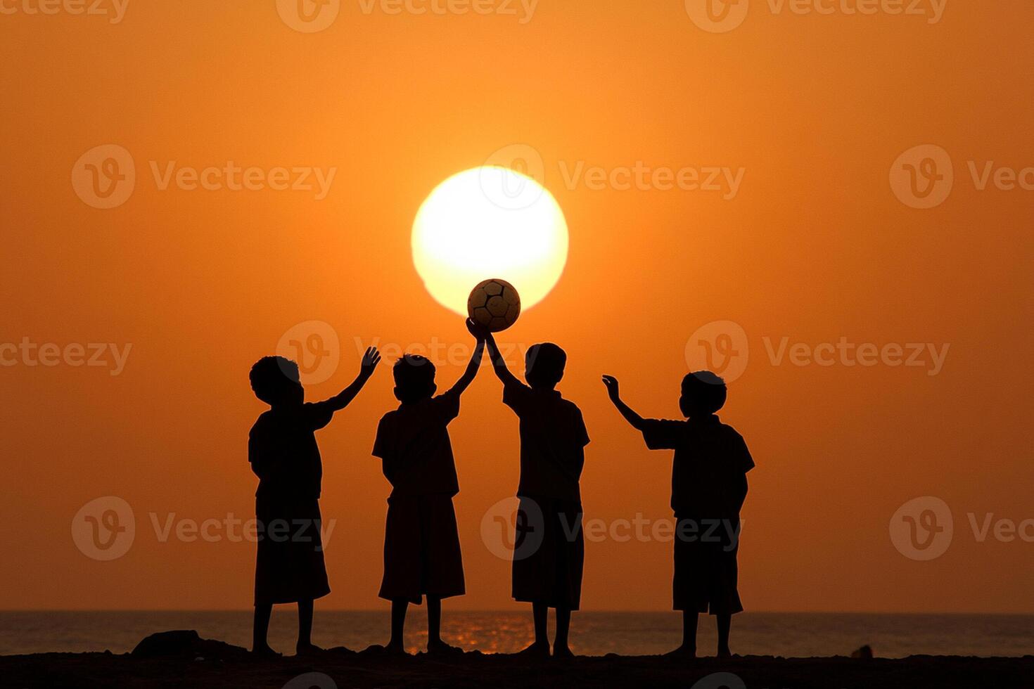 A group of kids standing on a beach holding a ball photo