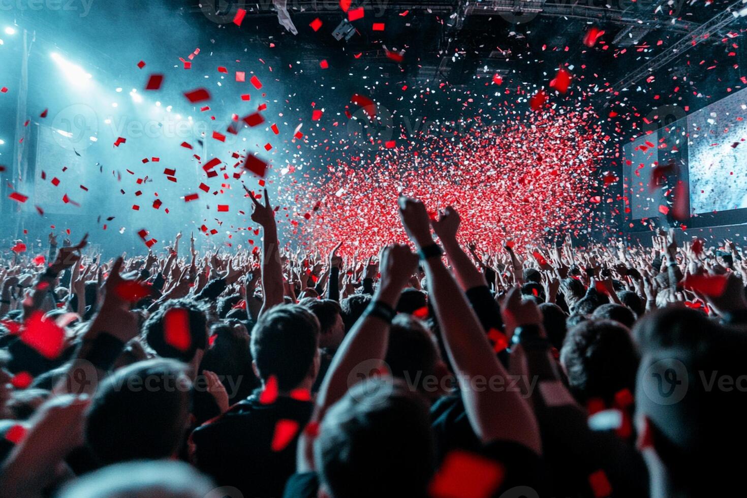 A crowd of people at a concert with confetti falling photo