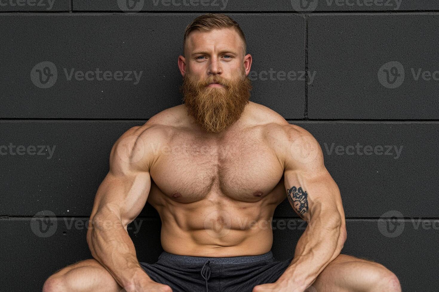 A man with a beard sitting on the ground photo