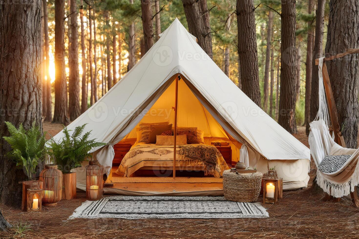 Cozy canvas tent illuminated at sunset in a tranquil pine forest photo