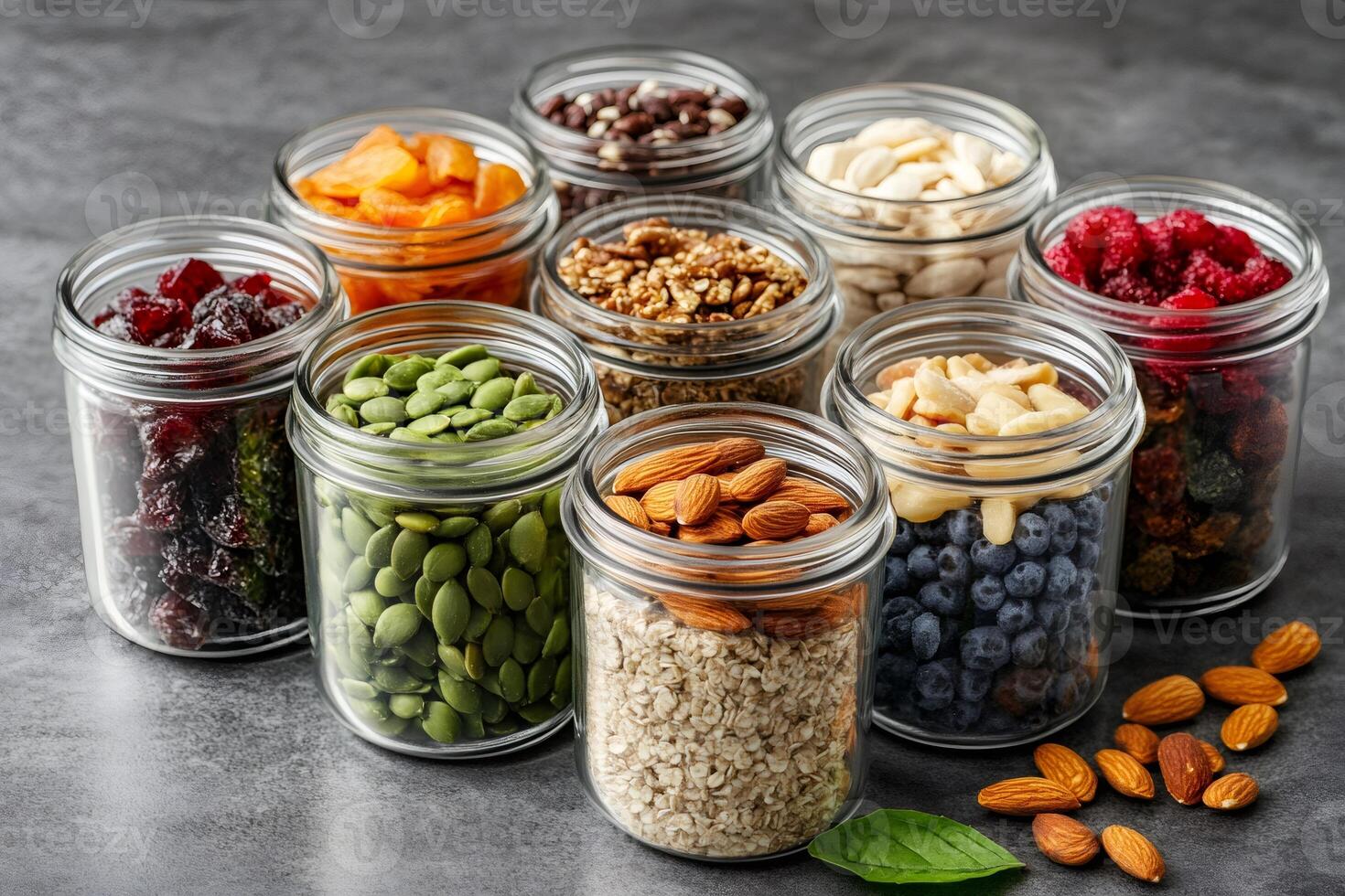 Variety of nuts, seeds, dried fruits and berries in glass jars preserving healthy nutrients photo