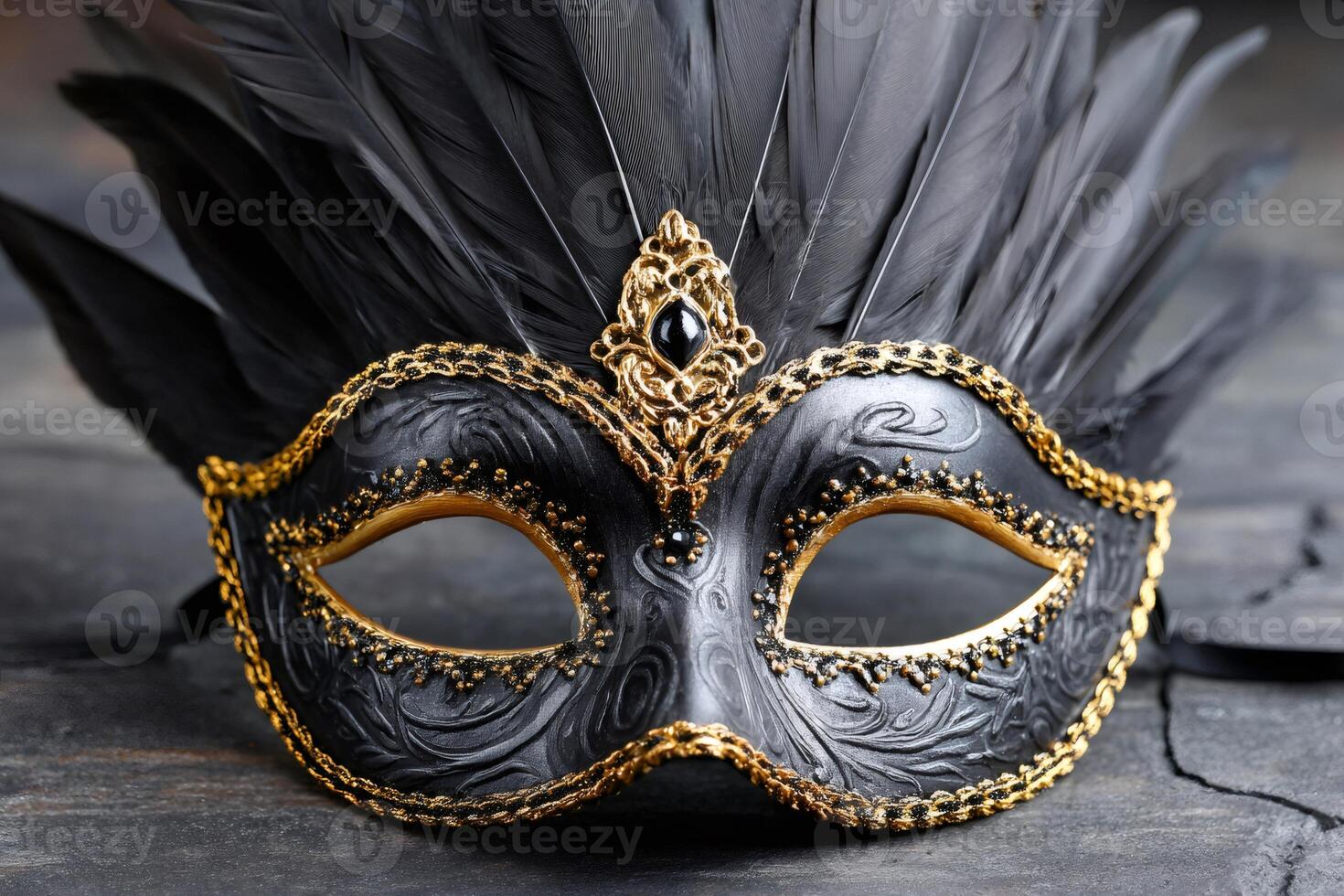 Elegant venetian carnival mask with black feathers and golden ornaments resting on dark wooden surface photo