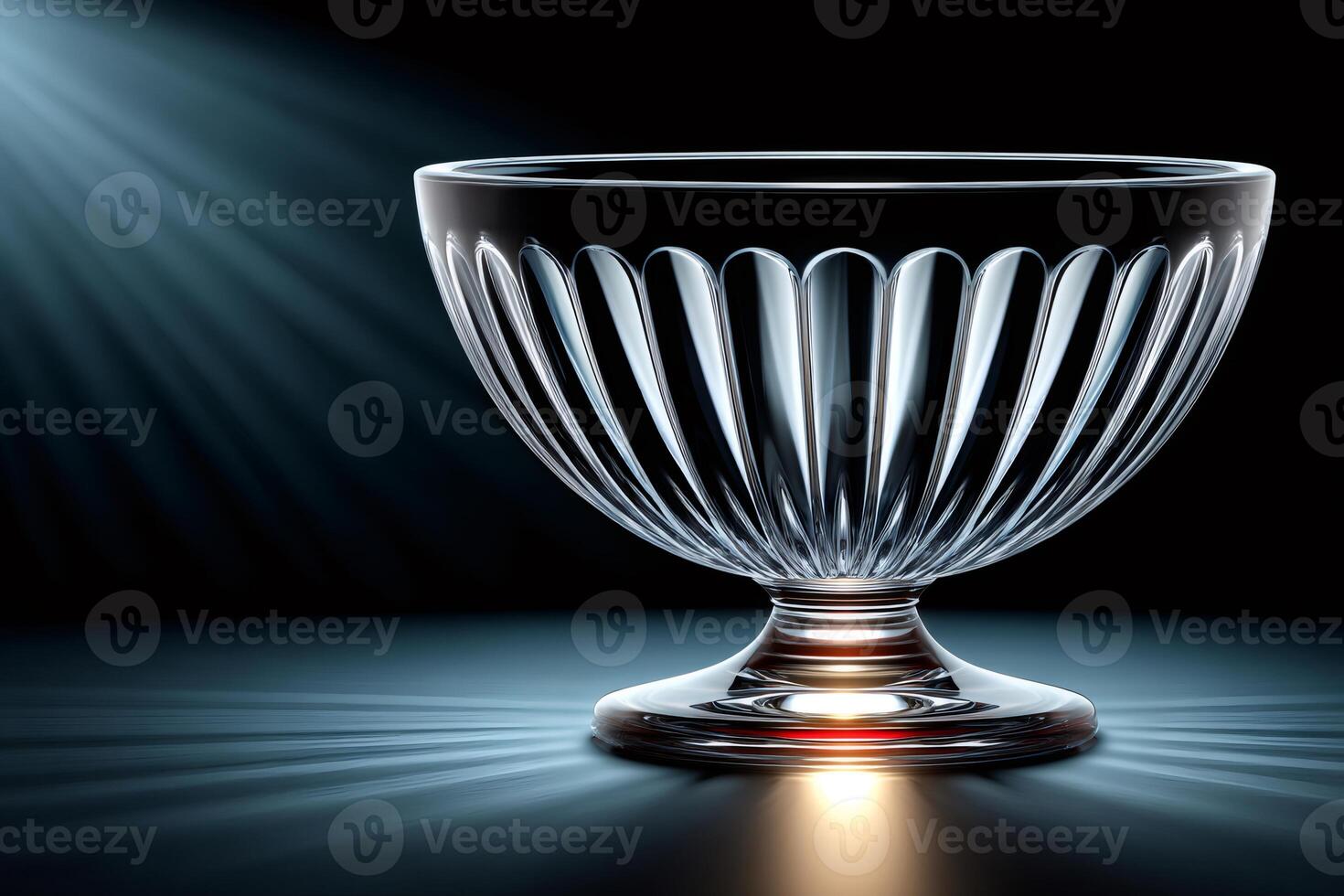 Empty crystal bowl shining under spotlights on dark background photo
