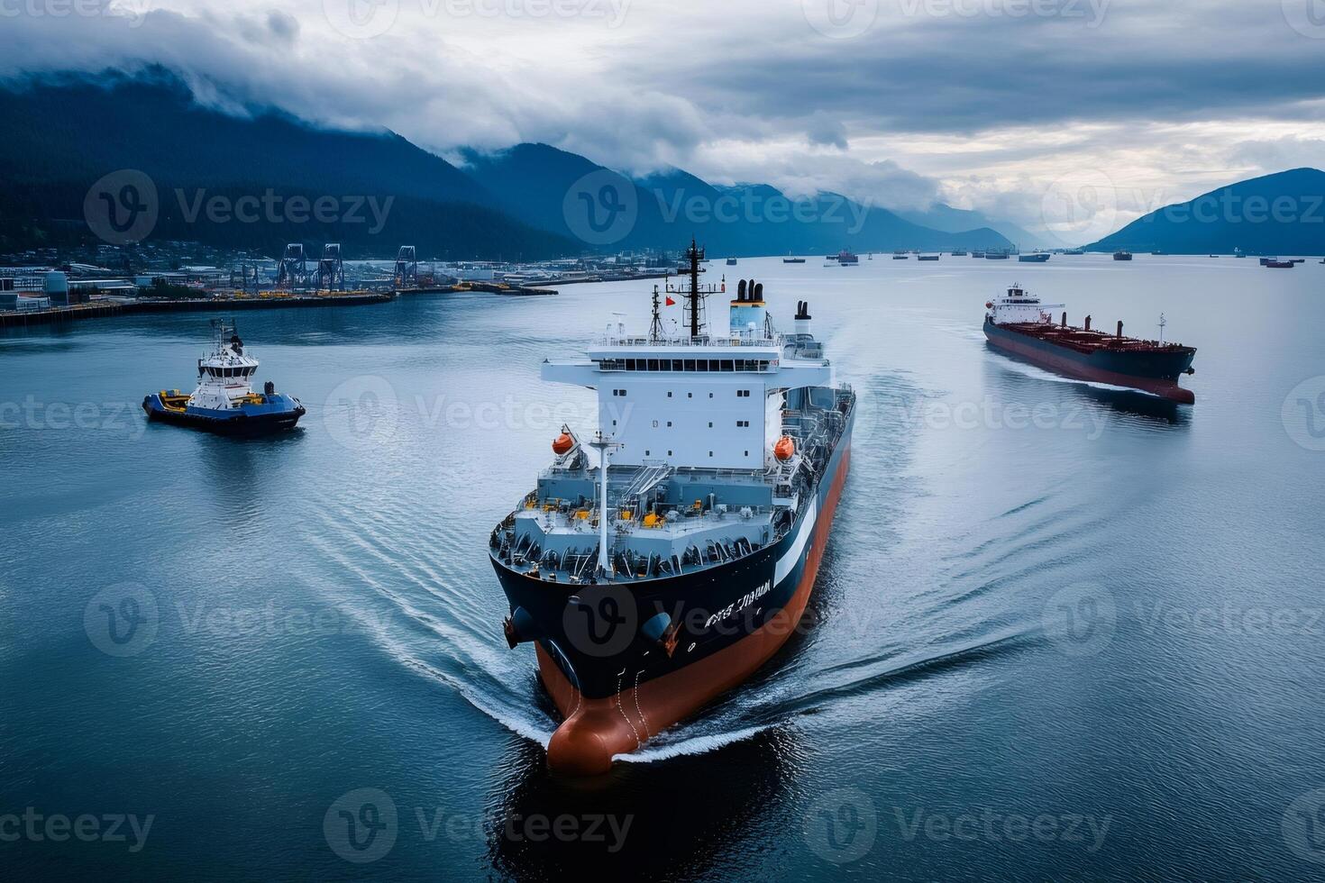 Cargo ships navigating industrial waterway with mountainous backdrop photo