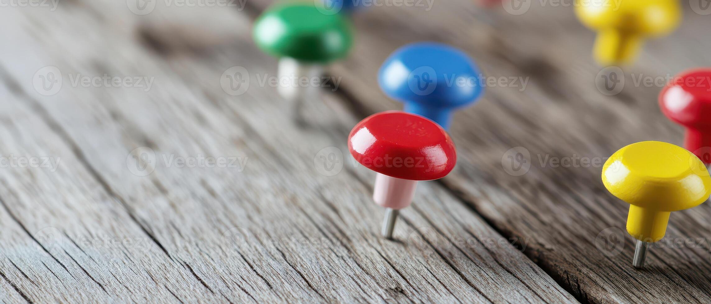 Colorful push pins on weathered wooden surface photo