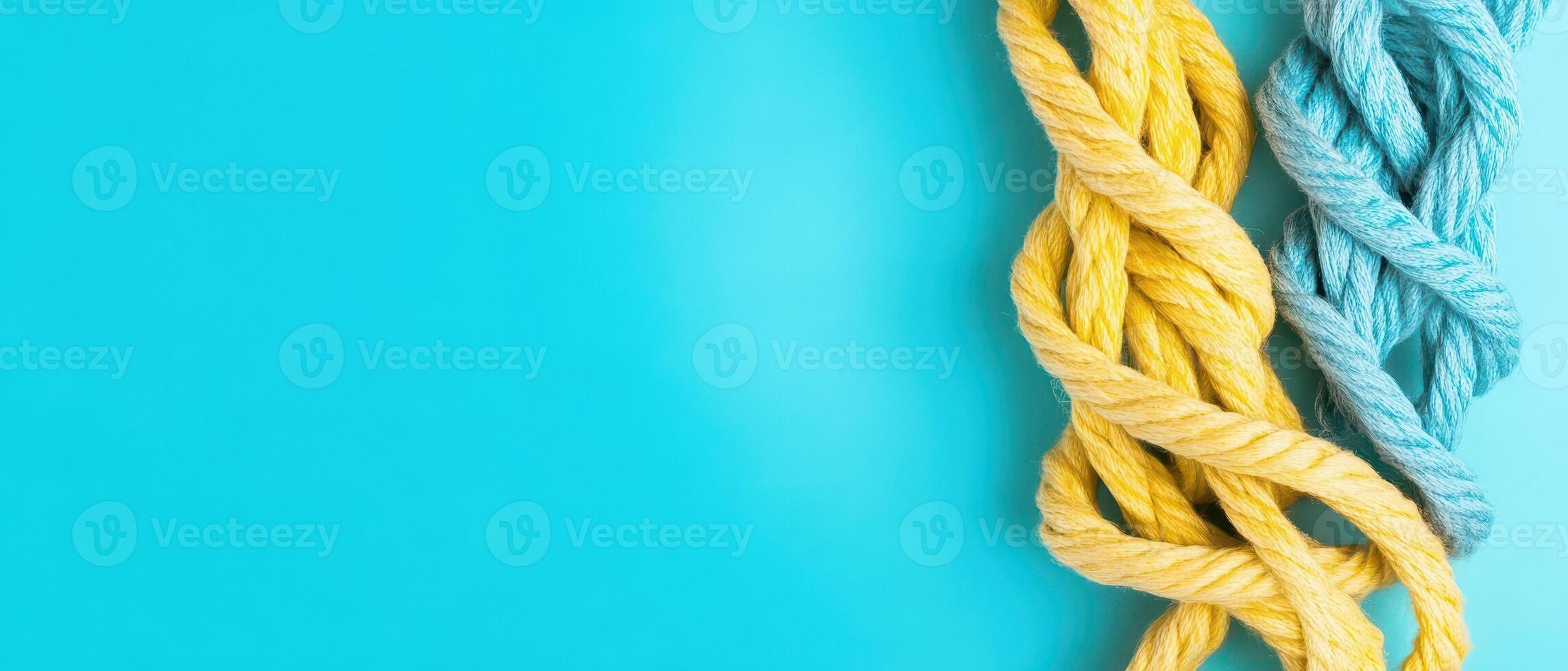 Colorful twisted ropes on a bright blue background photo