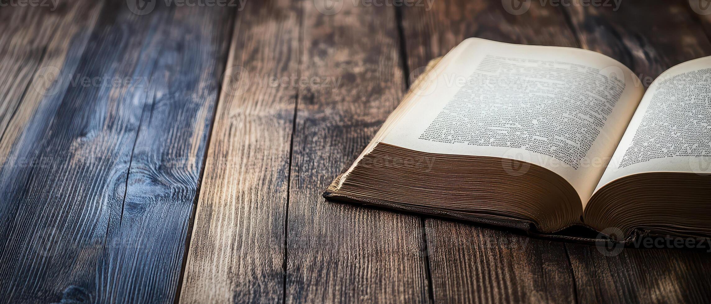 Open book resting on a wooden table surface photo