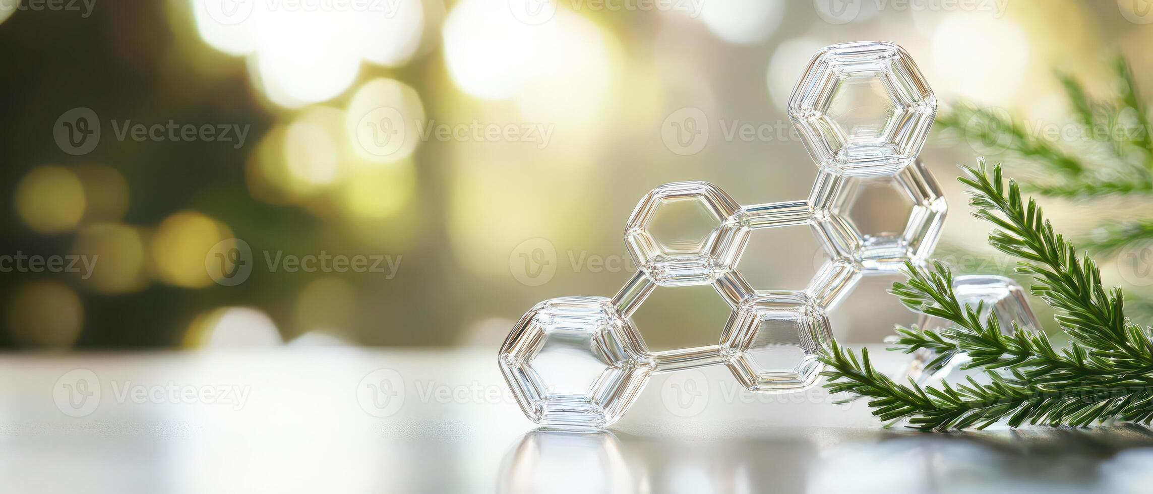 Glass molecular model beside evergreen branches photo