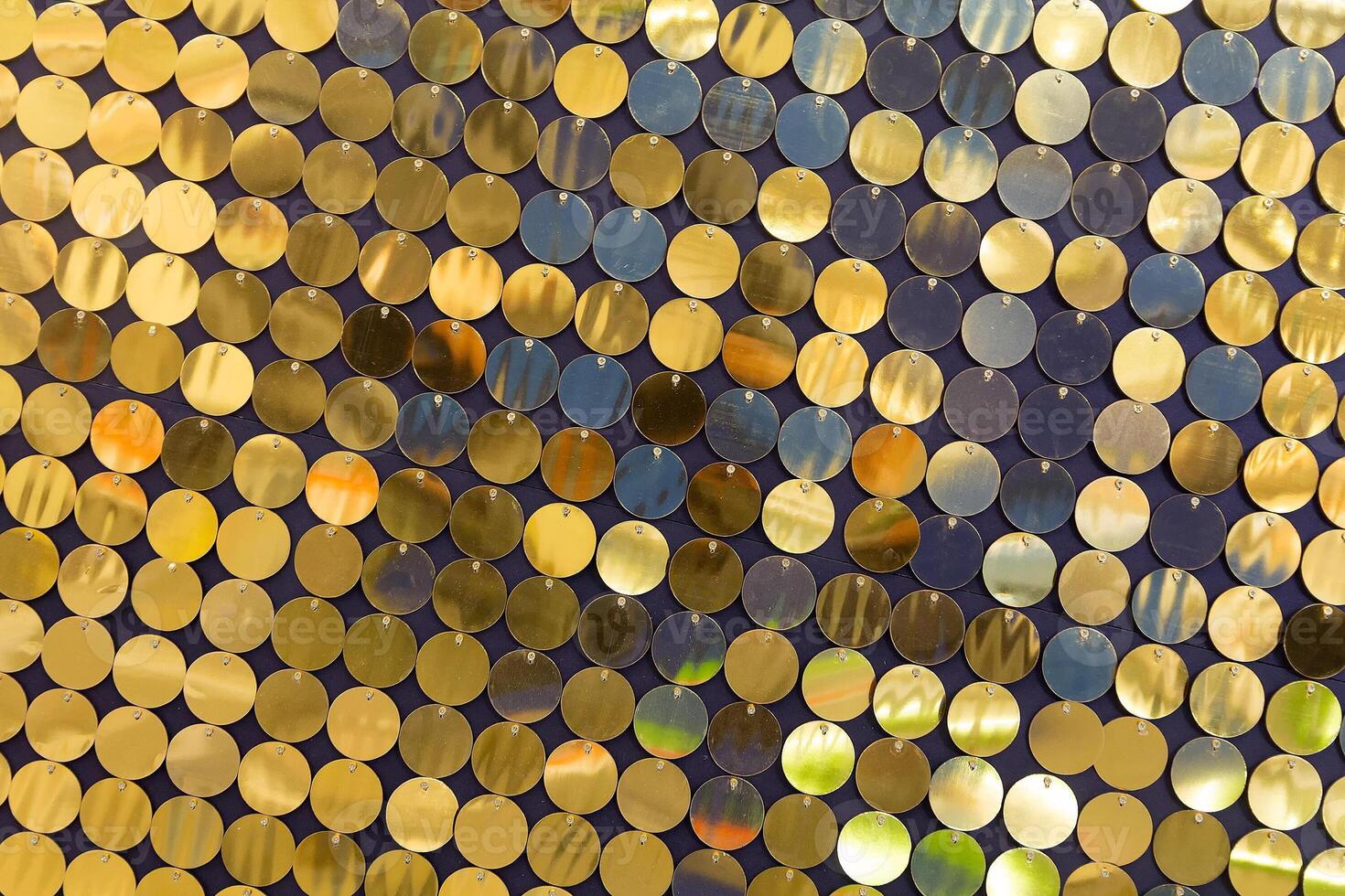 Background from golden sequins in matrix form. Concept of holidays, celebration events and costume parties photo