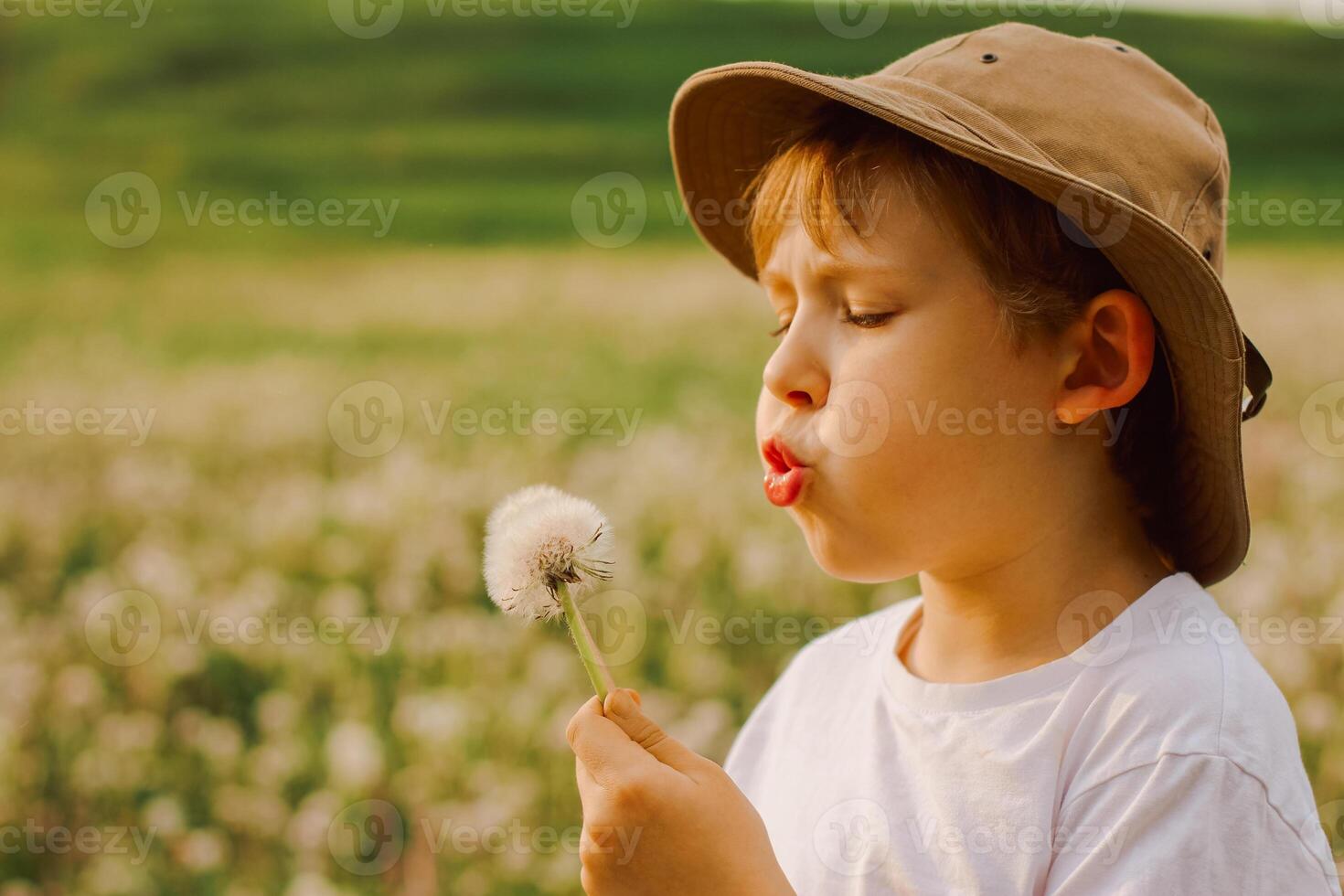 Close up of a child blowing dandelion seeds photo