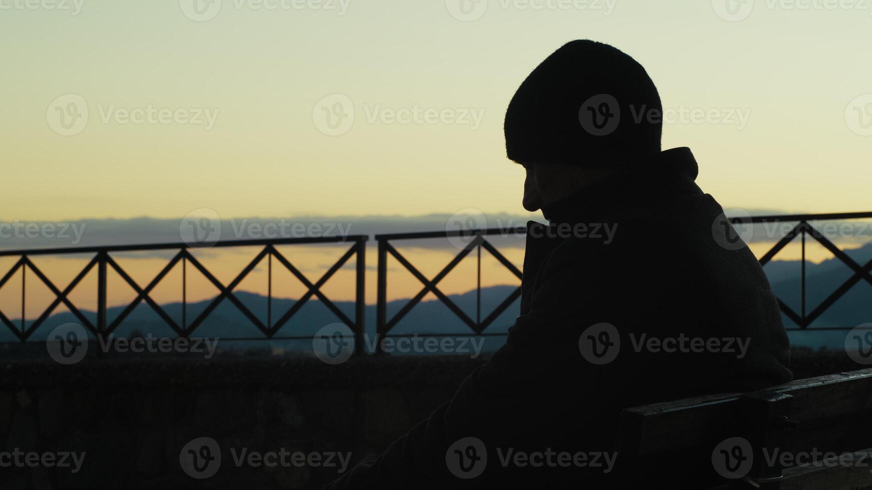 Silhouette Of A Man Sitting On Bench Watching Time Pass Outdoor photo