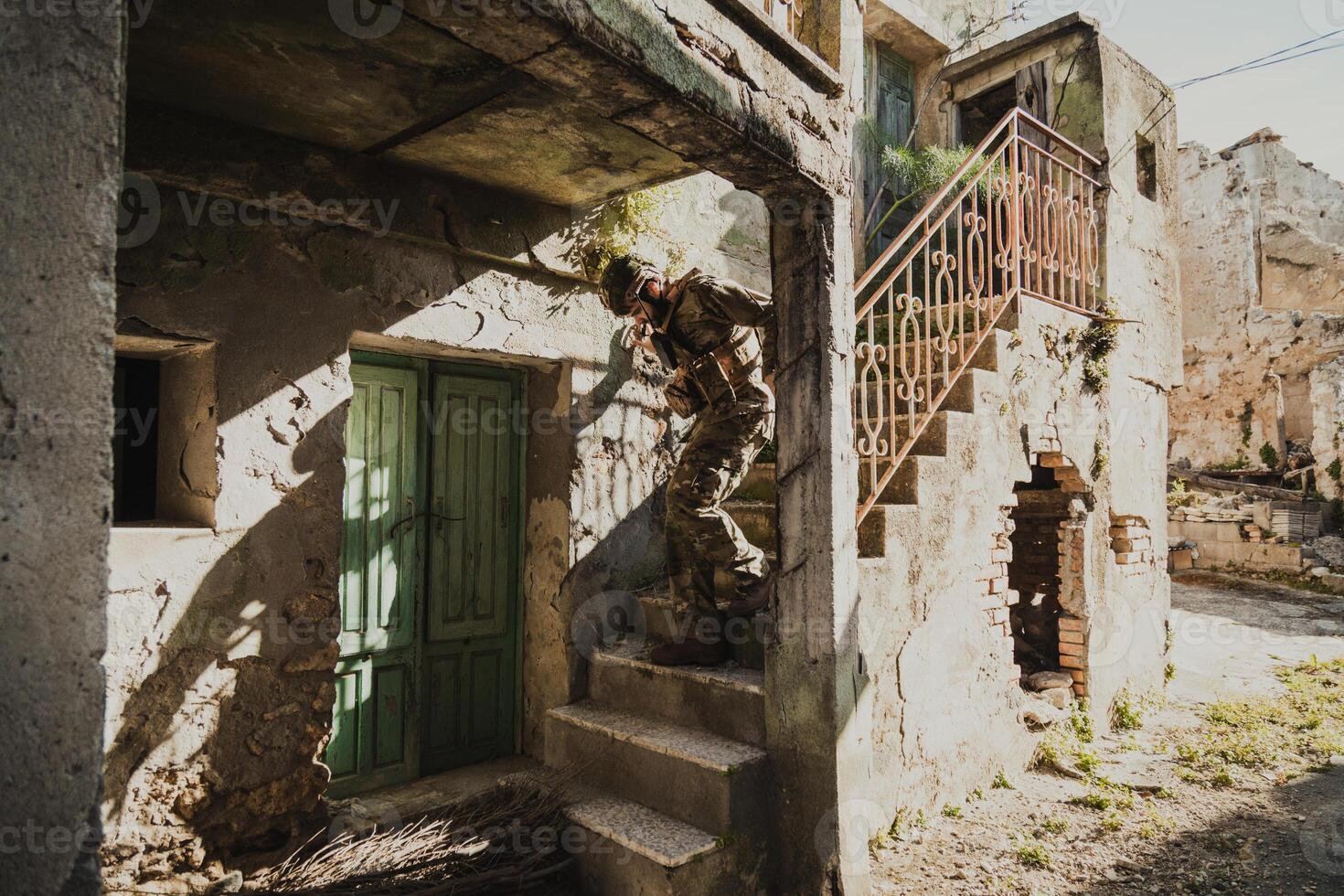 Soldier Carefully Goes Down The Stairs Of A Destroyed House photo