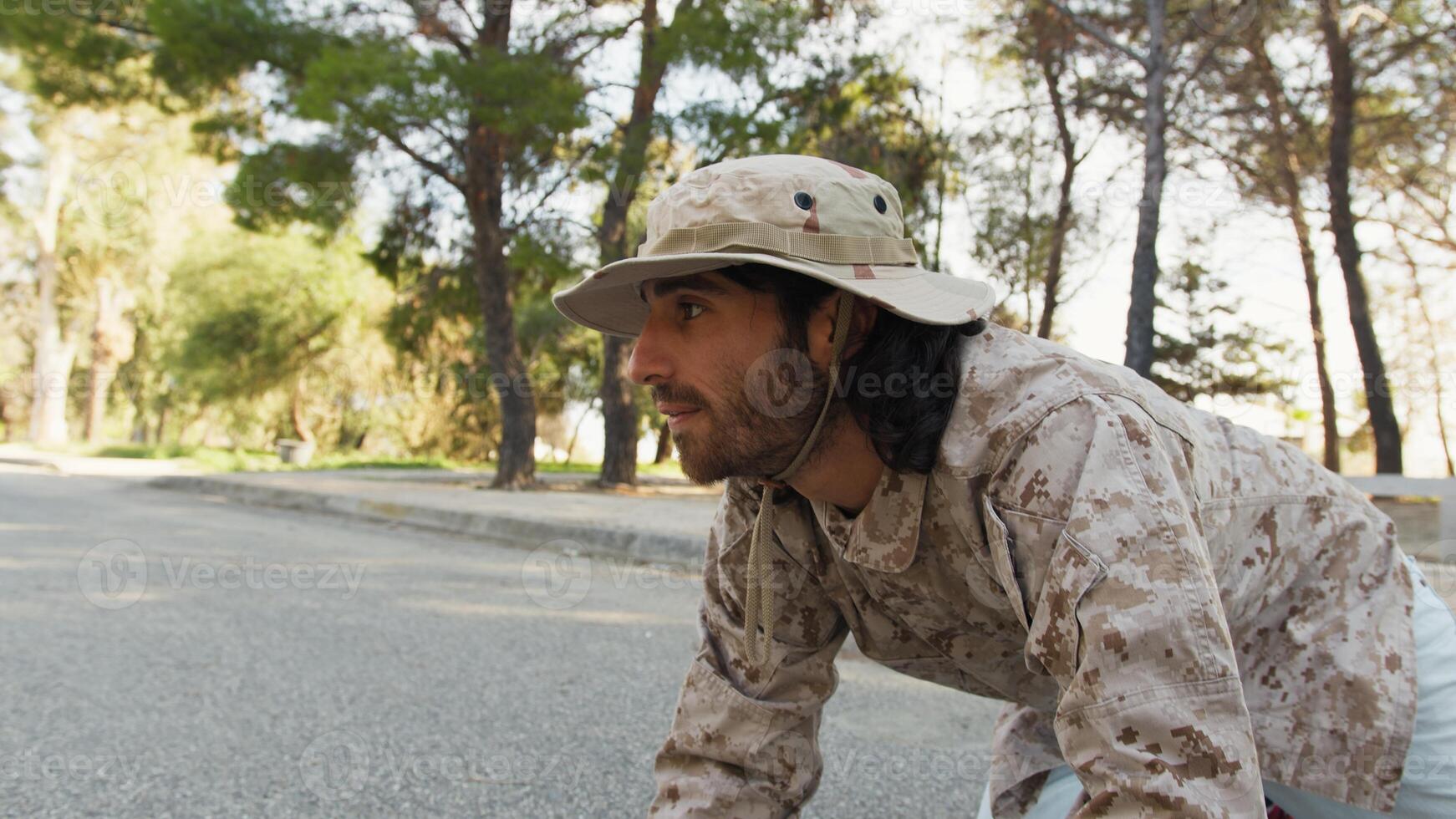 Soldier Crawls On The Ground And Smiling Approaches A Cat To Save It In Street photo