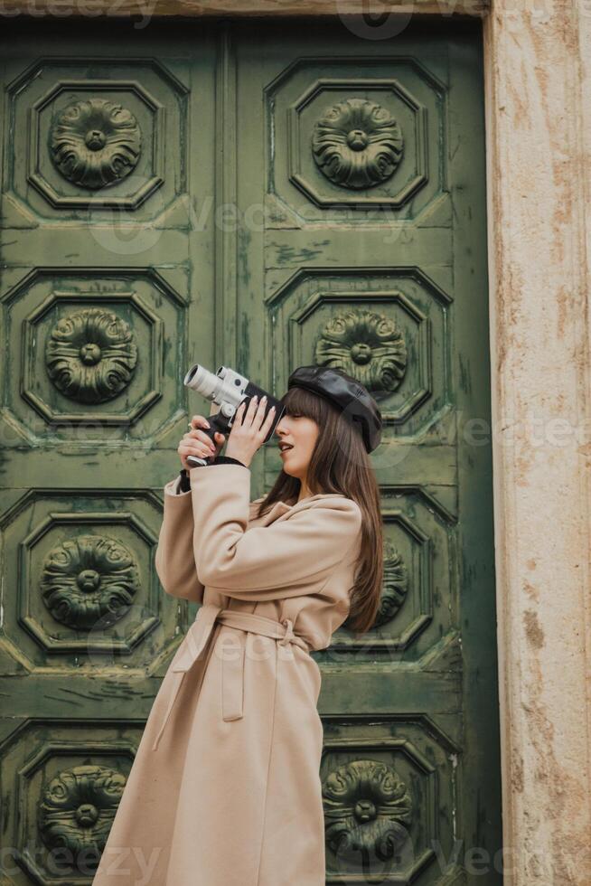 Woman Filming The Old Hamlet Buildings With A Vintage Camera photo