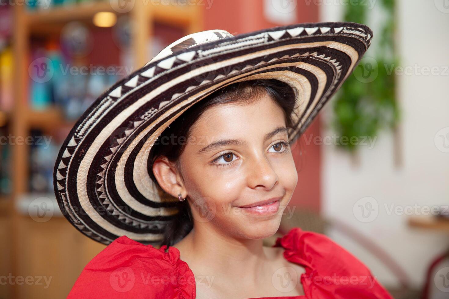 Sweet teenager girl in Cartagena de Indias wearing a traditional sombrero vueltiao. Travel concept. Sitting alone. Happy girl. photo
