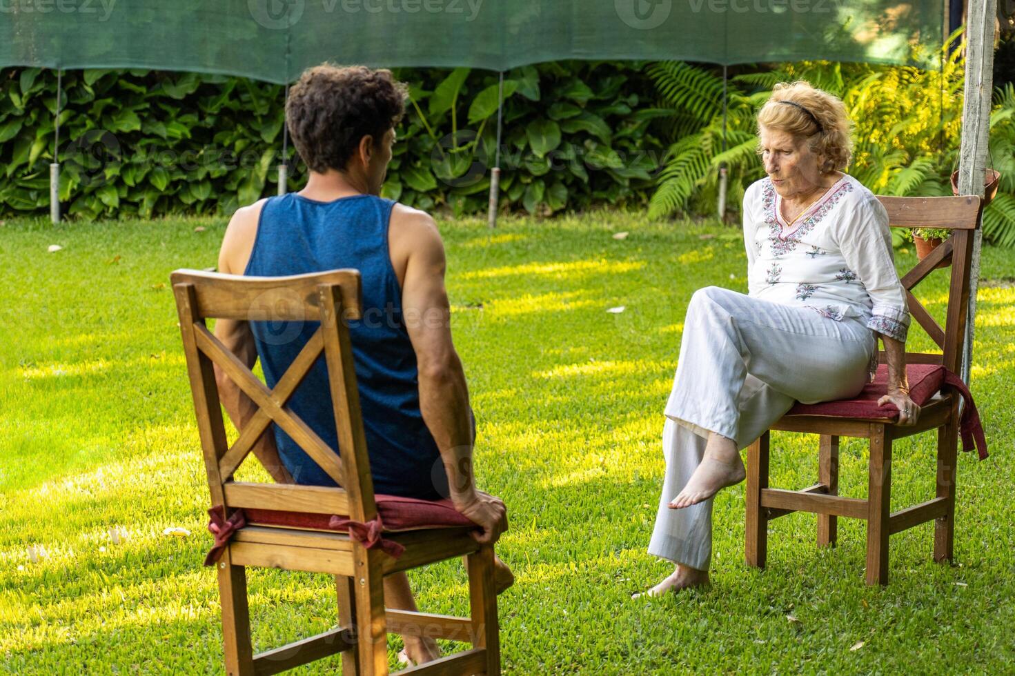 Senior woman and physiotherapist doing exercises outdoors in rehab session photo