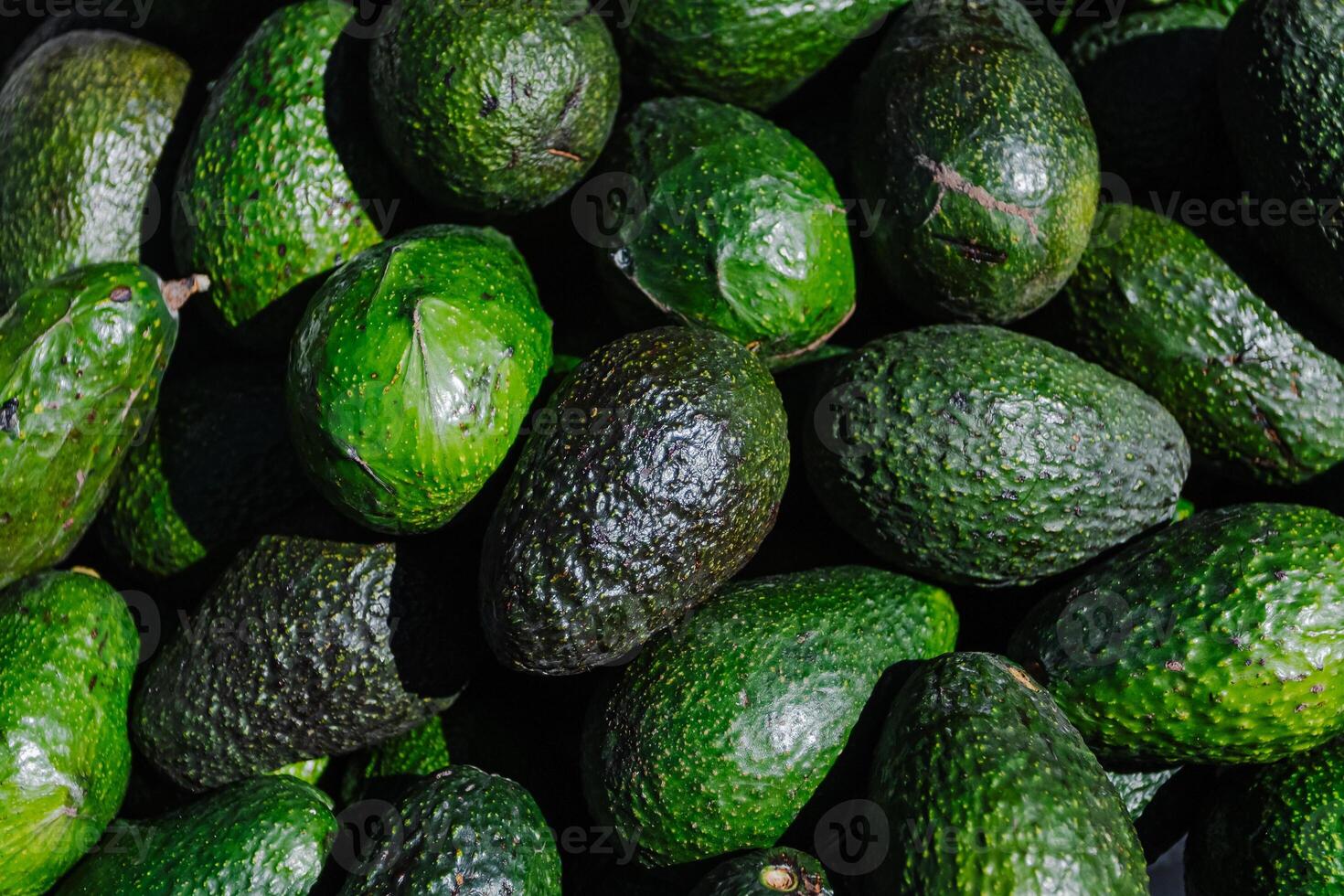 avocados are piled up in a pile photo