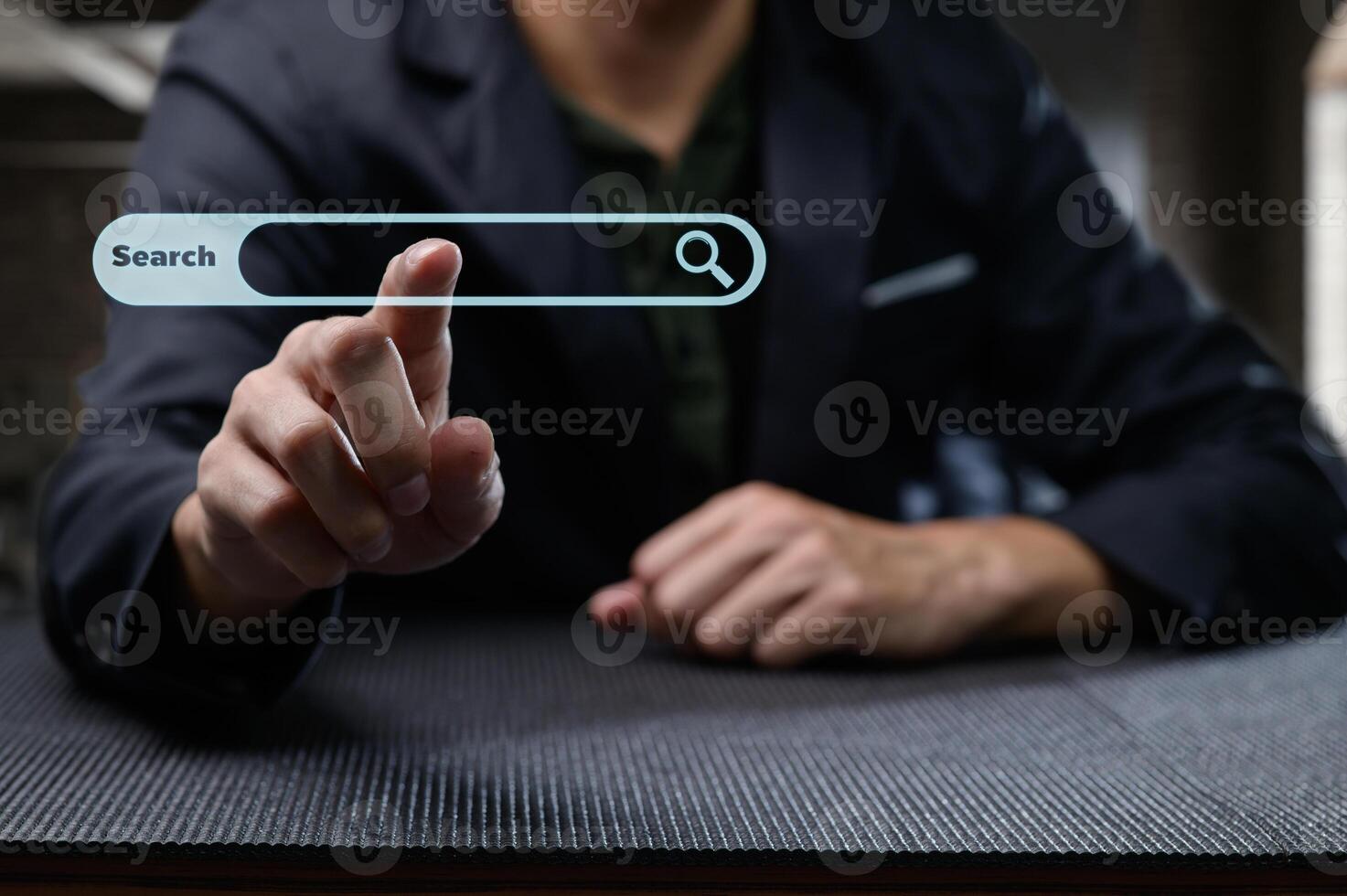 Man in Suit Touching Virtual Search Bar Display on Table photo