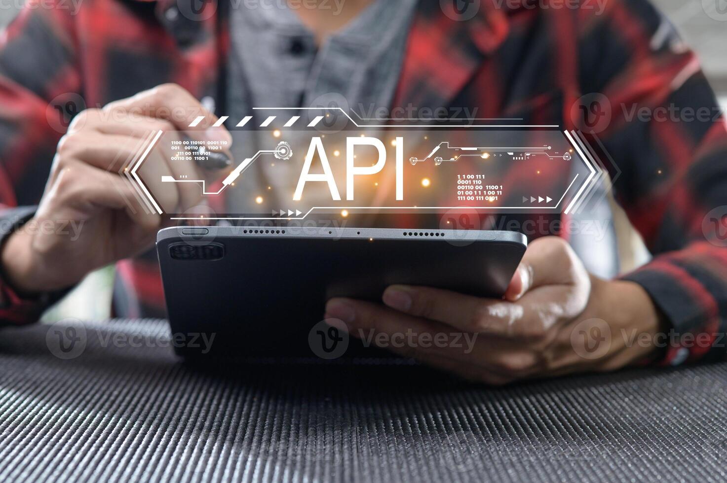 Person Using Tablet with API Interface Graphic Overlay photo