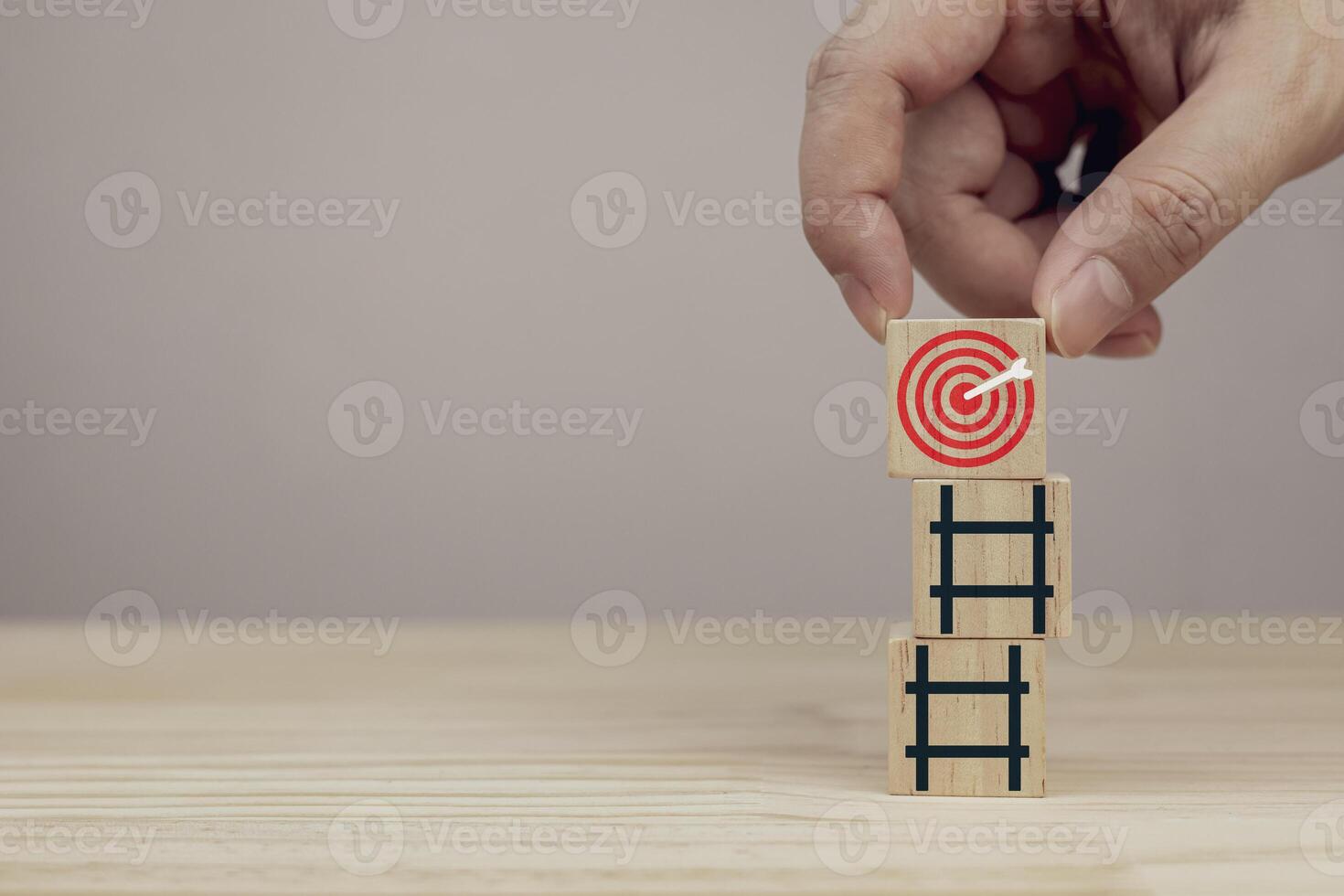 Hand placing wooden blocks with red dartboard on stairs. Concept of business strategy planning and goal setting, with copy space photo