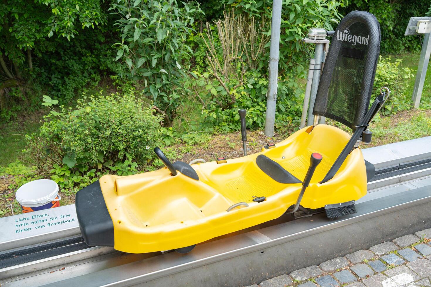 Homberg, Germany, 06.09.25. Bright Yellow Summer Toboggan on a Track photo