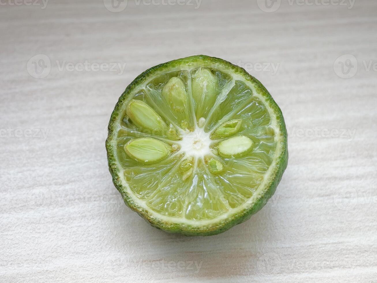 Close-up of a Freshly Sliced Green Citrus Fruit with Visible Seeds and Juicy Pulp photo
