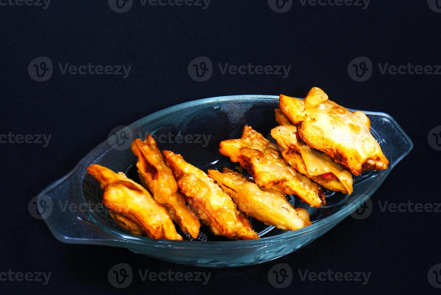 A clear glass bowl brimming with golden fried chicken wings, showcasing their delicious, crispy texture. photo