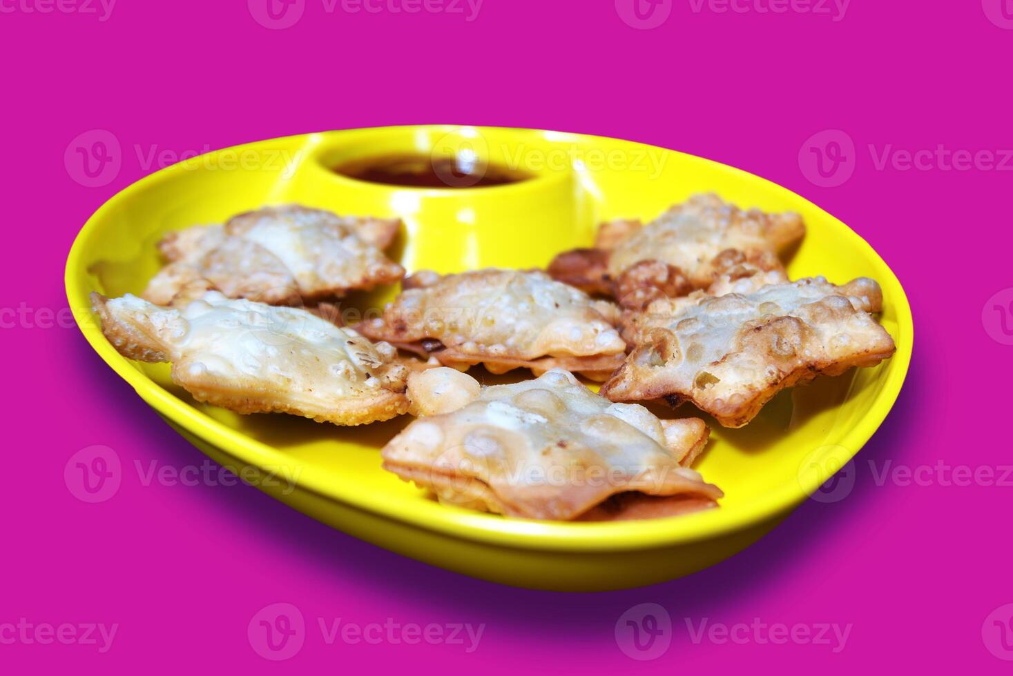 Crisp and Buttery Star Aloo Puffs Resting on Sleek Black Marble with Savory Tomato Kick - A Stunning Appetizer for Any Gathering, Isolated on Pink BG photo